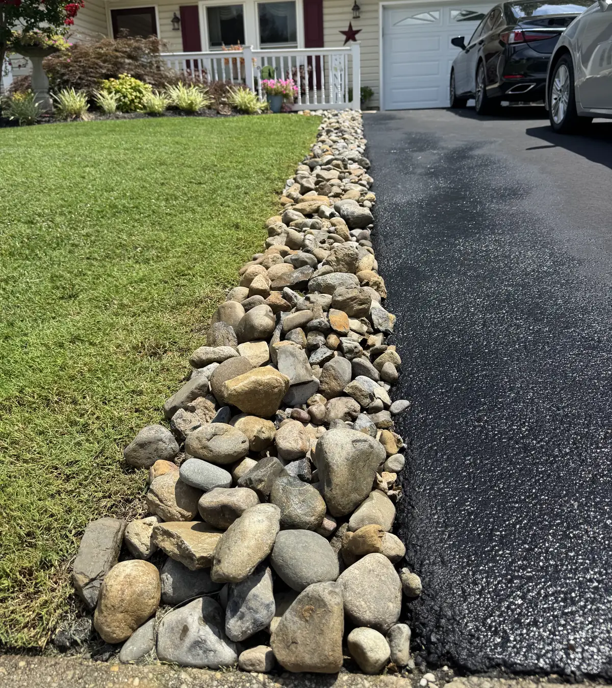 A river rock channel running beside a driveway
