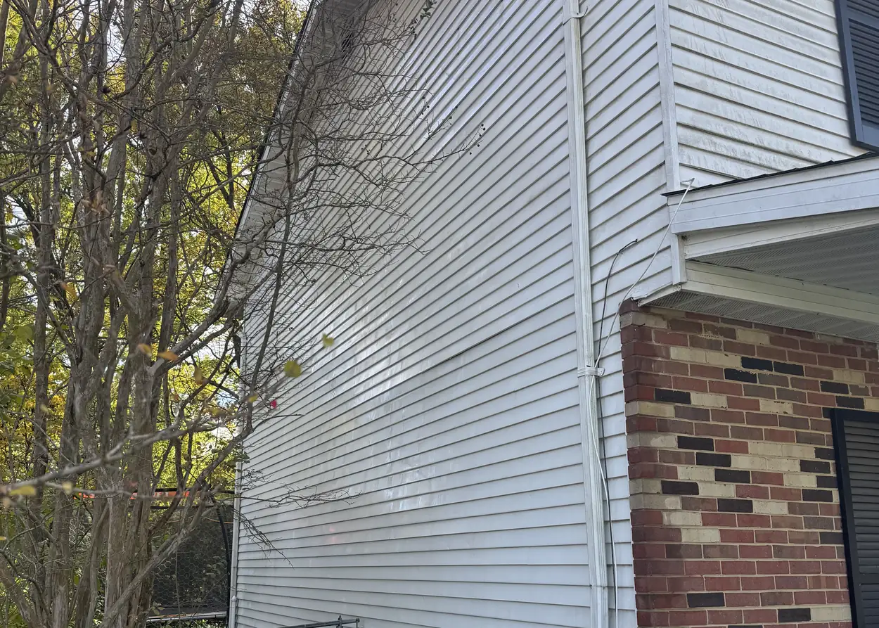 Clean white siding on a two-story home, with a brick corner beside it