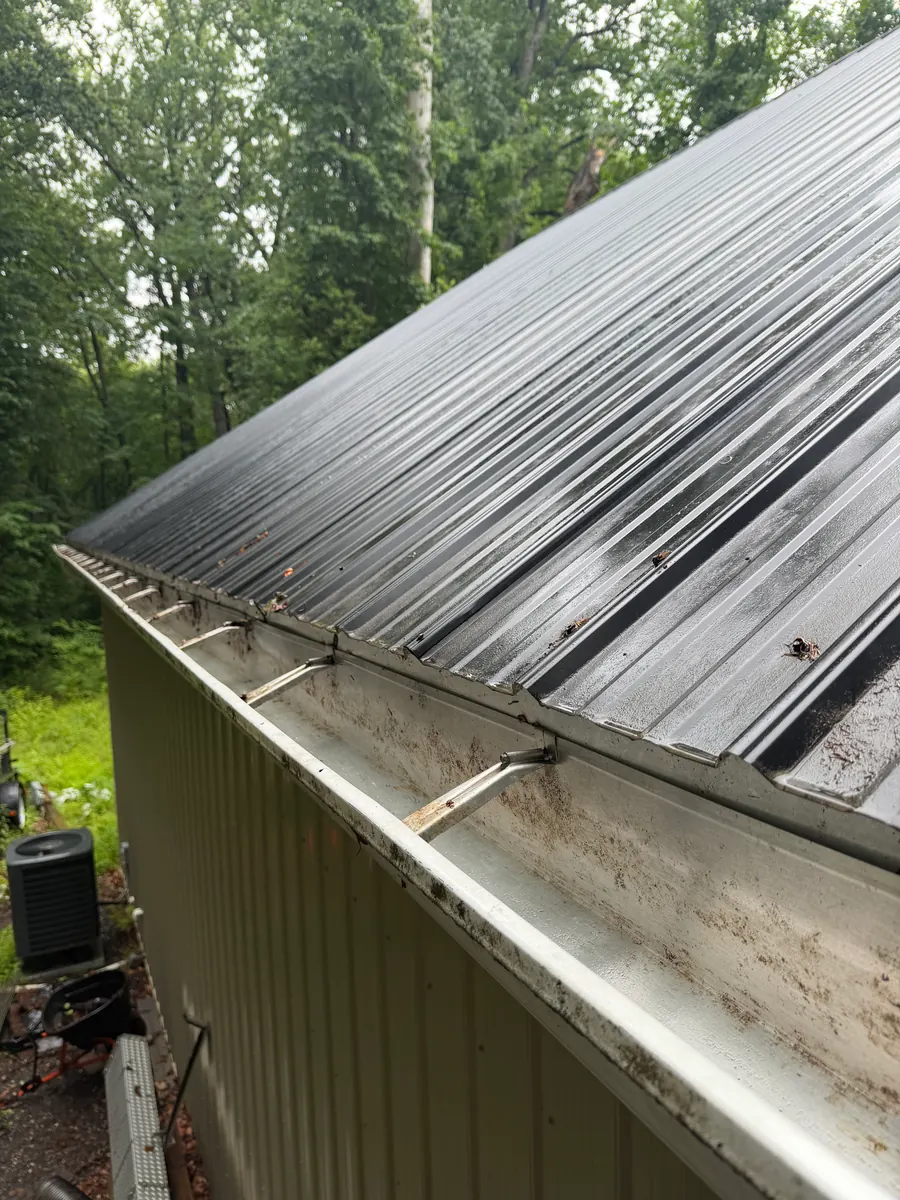 A cleaned gutter along a metal roof