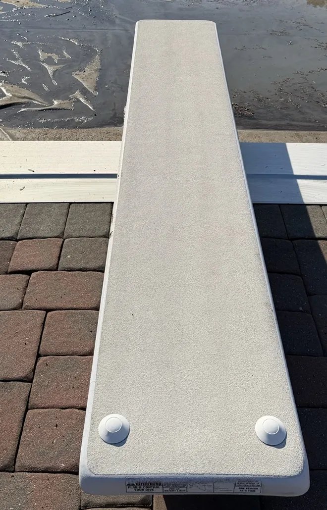 A clean diving board over brick pavers