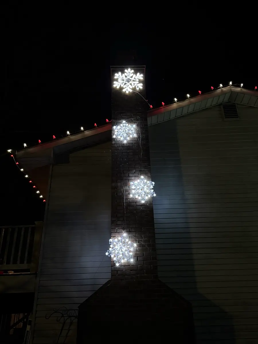 Lit snowflakes mounted on a chimney